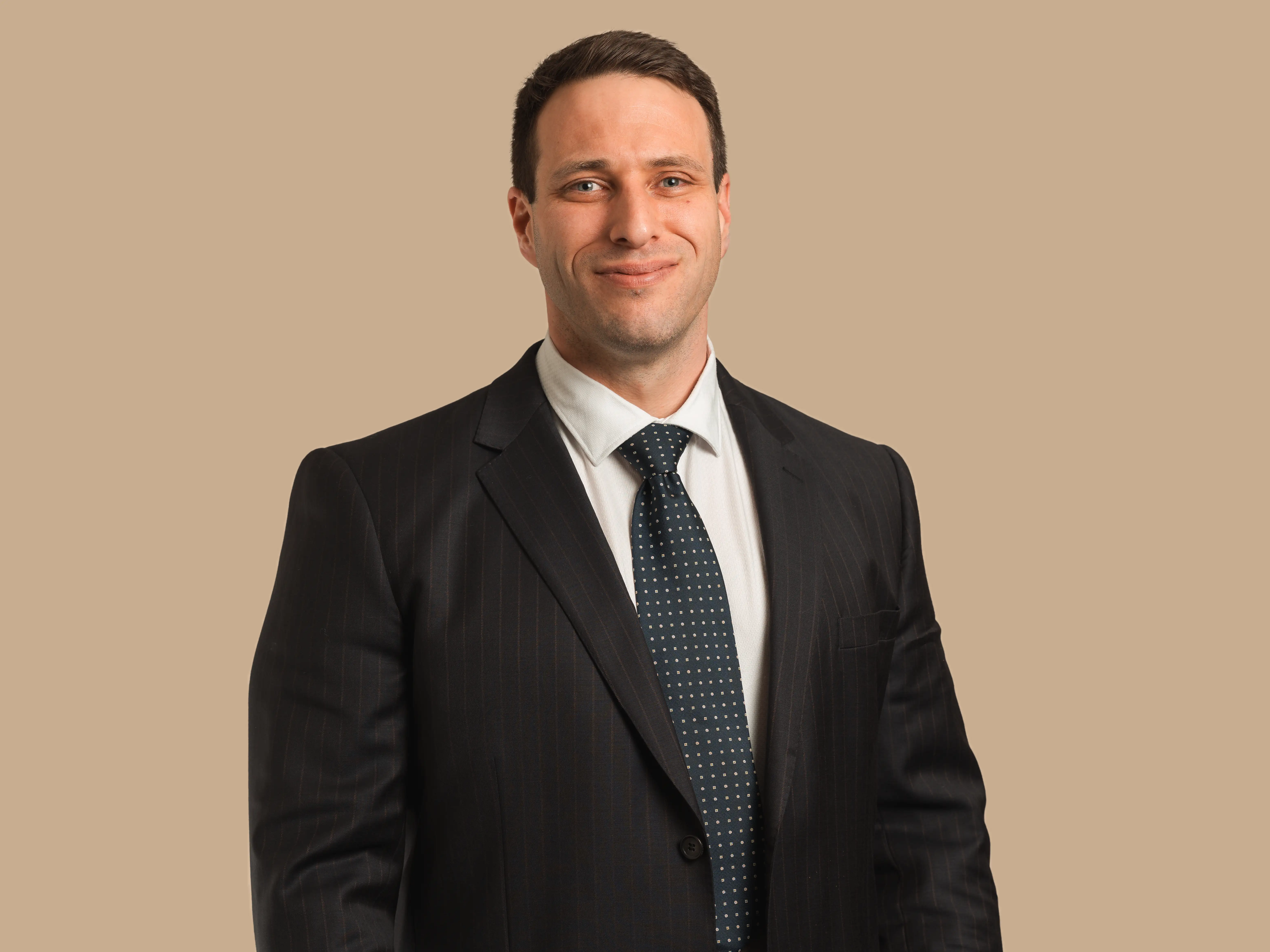 Shane wears a dark suit and blue tie