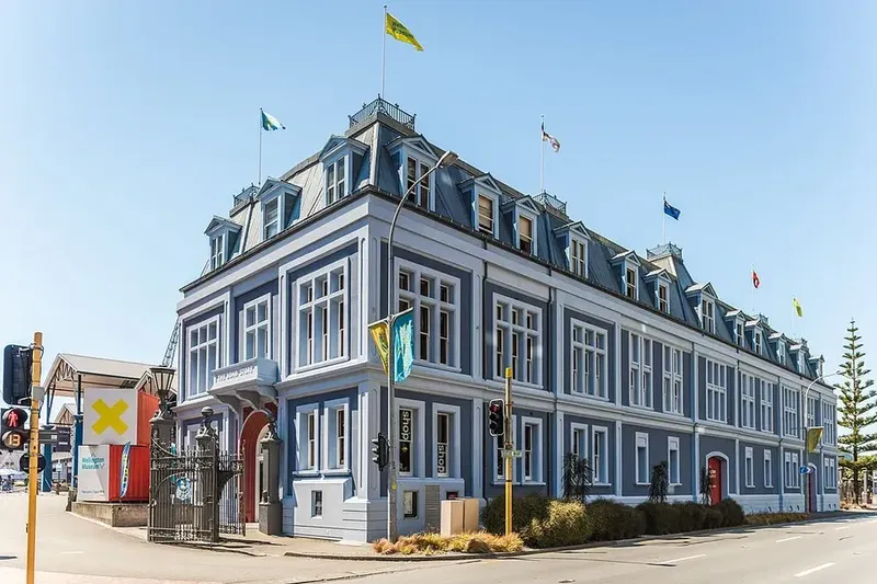 an old blue building covered in flags on the wellington waterfront