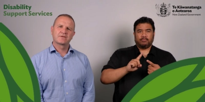 Chris Bunny stands next to a gentleman signing in NZ Sign Language