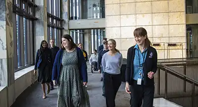 A handful of people walk the halls of the New Zealand's beehive as part of their guided tour.