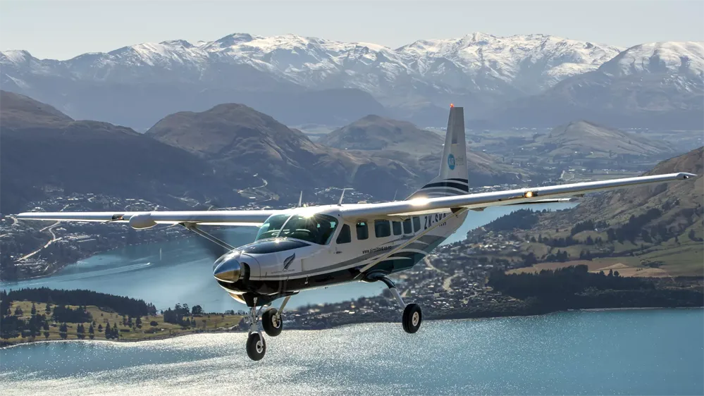 small plane flying over queenstown with the remarkables in the background