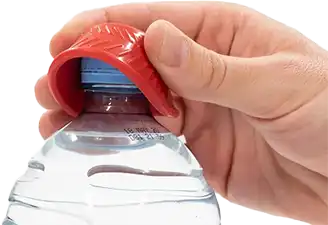 A red, circular rubber lid opener with a textured, non-slip surface opens a water bottle.