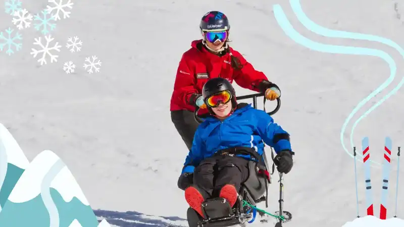 An adaptive skiier is getting supported to skii down a mountain