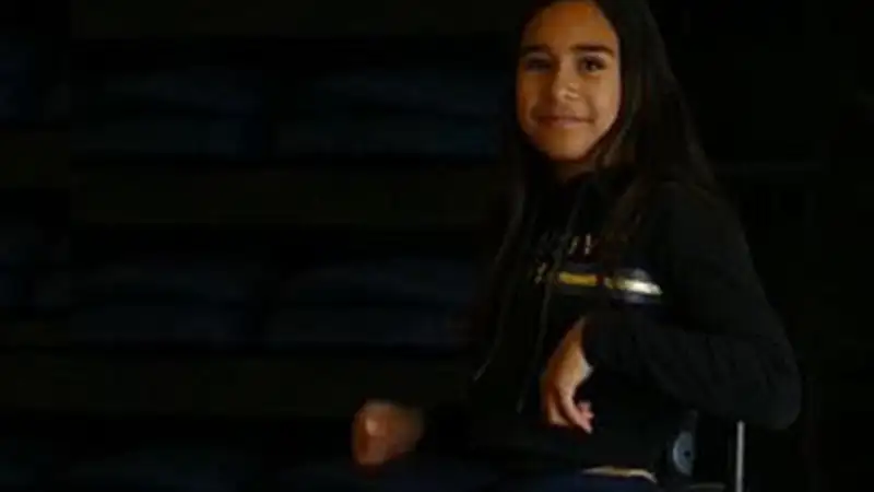 Harper is a young māori girl with long dark brown hair who uses a wheelchair