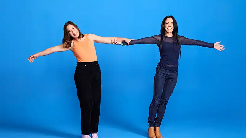 Molly and Kate hold hands. They are both Māori women.