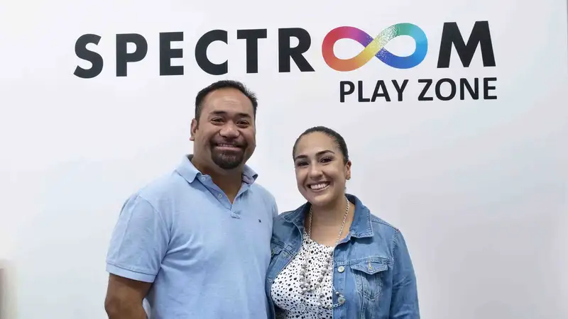 Mac is a polynesian man and stand next to his wife Maria from Mexico. Spectroom PlayZone appears above their heads.