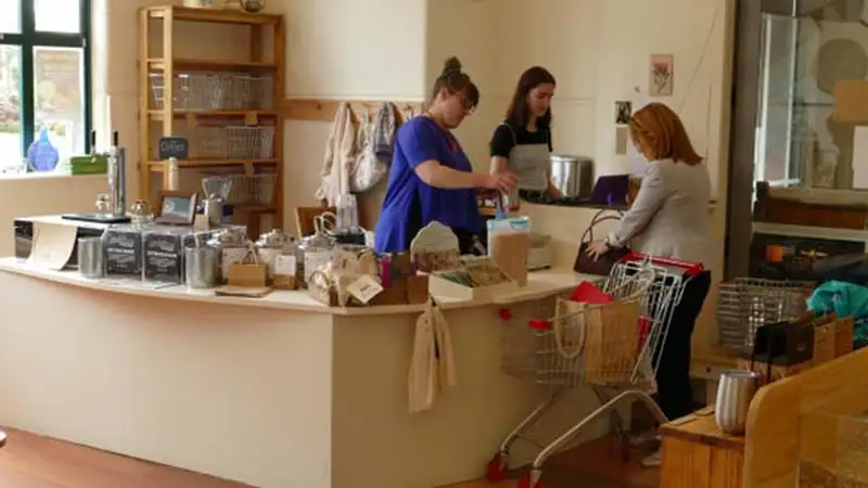 A person is being served at a store counter which is at regular table height